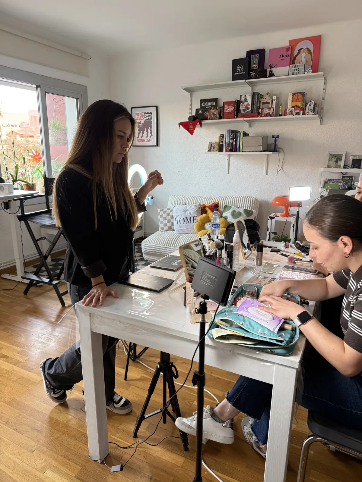 Alumna practicando con su propio neceser mientras la maquilladora la guía en el estudio de Barcelona