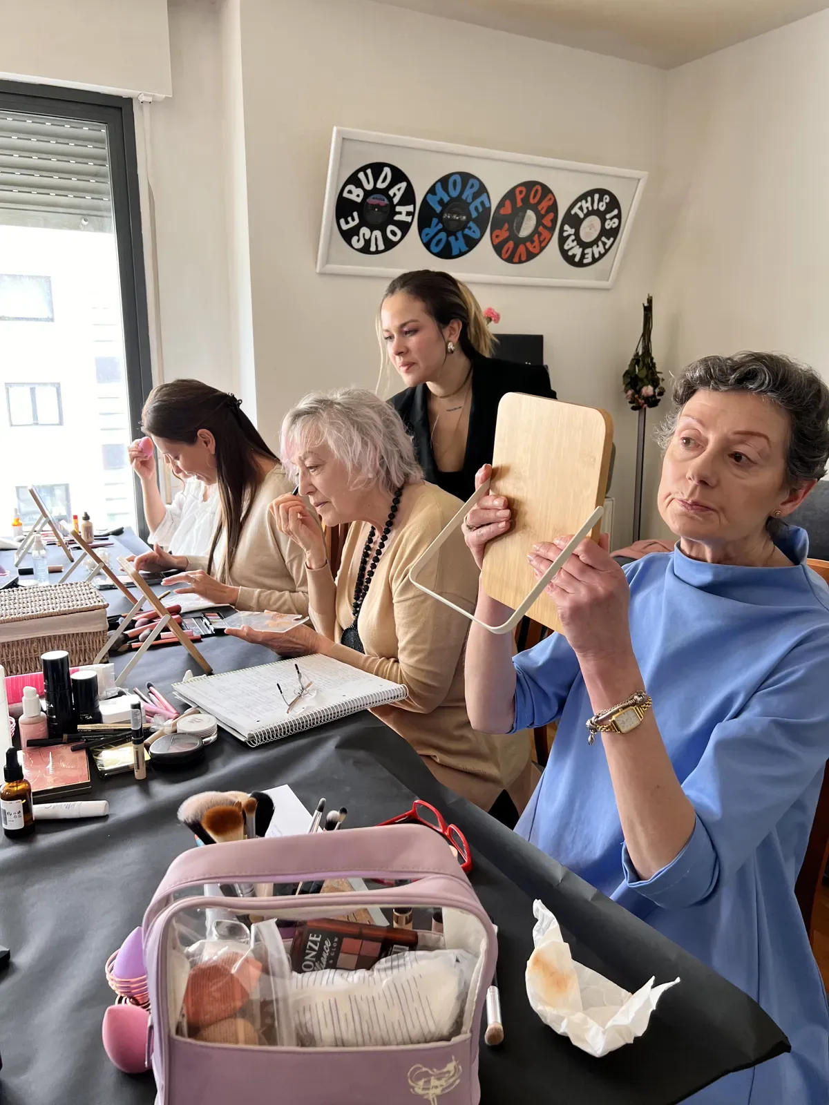 Grupo de alumnas maquillándose con espejos durante una clase grupal de automaquillaje en Barcelona